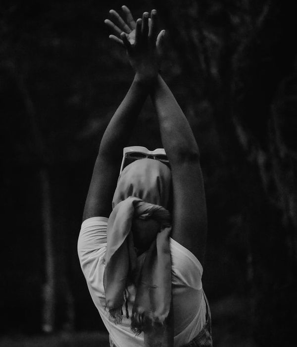 Woman in a calm yoga pose on a dark background with mint accents.