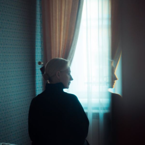 Woman meditating peacefully in a dimly lit room.
